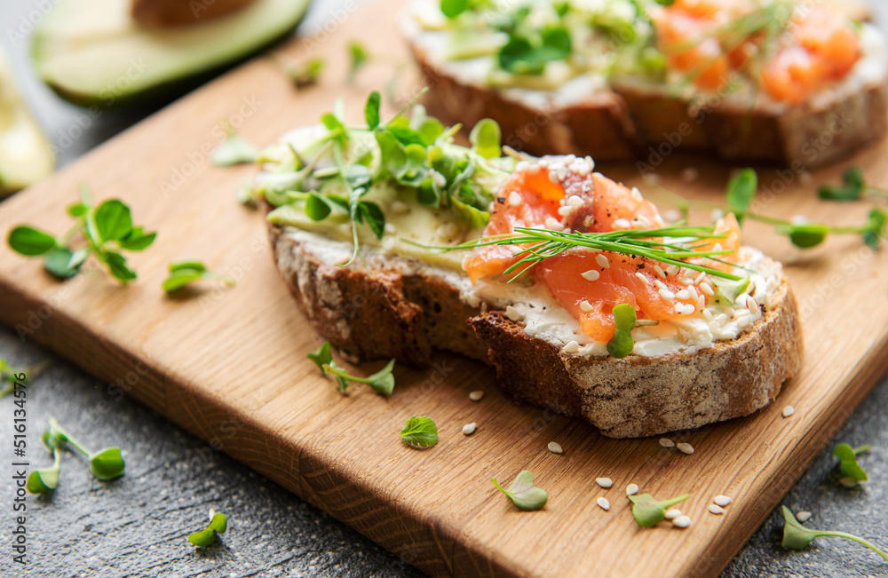 Sandwiches with salted salmon,  avocado and microgreens.