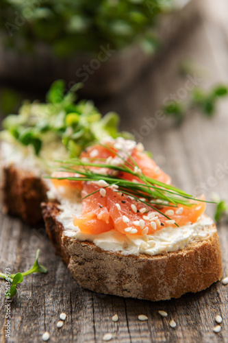 Sandwiches with salted salmon, avocado and microgreens.