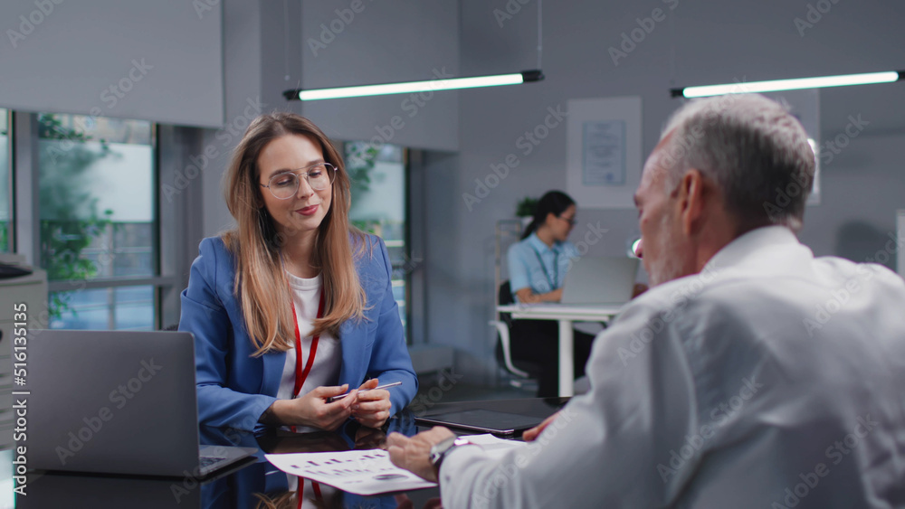 Obraz premium Mature entrepreneur consult with financial advisor in modern bank