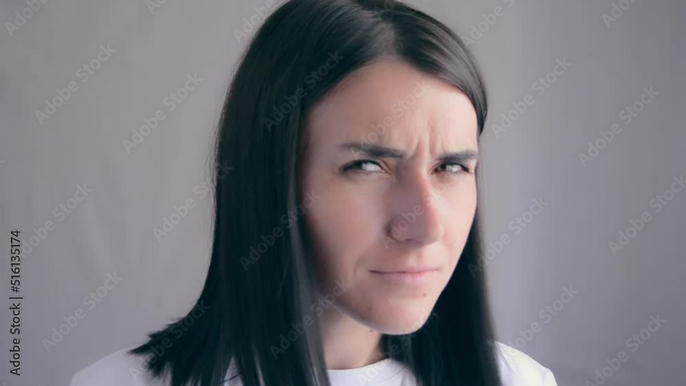 Curious, suspicious woman looks with disbelief isolated on gray background. Young attractive woman looks skeptical and shows signs of mistrust. Portrait of a woman suspecting a lie. Funny woman Curious, suspicious woman looks with disbelief isolated on gray background. Young attractive woman looks skeptical and shows signs of mistrust. Portrait of a woman suspecting a lie. Funny woman