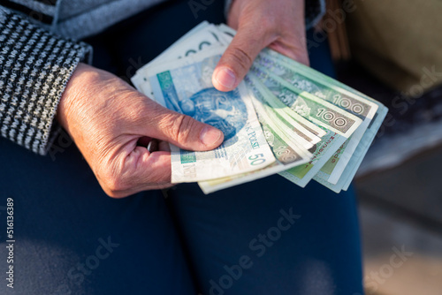 a pensioner holds in her hands banknotes in zloty pensions for payment photo