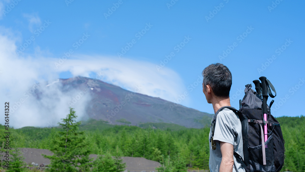 富士登山に挑戦する男性　富士山バック　
