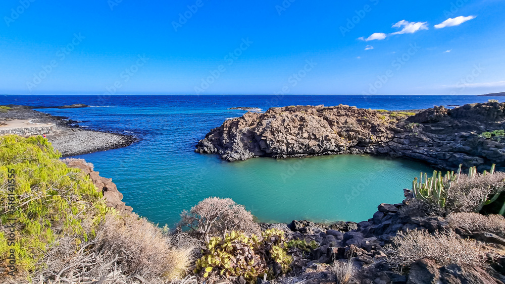 Scenic view on beach Playa El Barranco near Amarilla, Golf del Sur, Tenerife, Canary Islands, Spain, Europe, EU. Cliff and rock formation creating a beautiful turquoise lagoon meandering like river