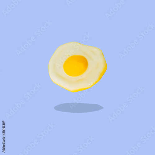Fried eggs float in the air on a blue background. Collage art.