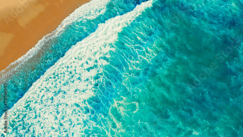 Beautiful ocean beach with yellow sand, aerial view.  Drone view of blue waves and sandy beach. Top view - Beautiful Ericeira beach is famous tourist destination.  Atlantic Ocean, Portugal.