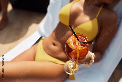 Close up of woman relaxing on deck chair and drinking cocktail on summer day Fototapet