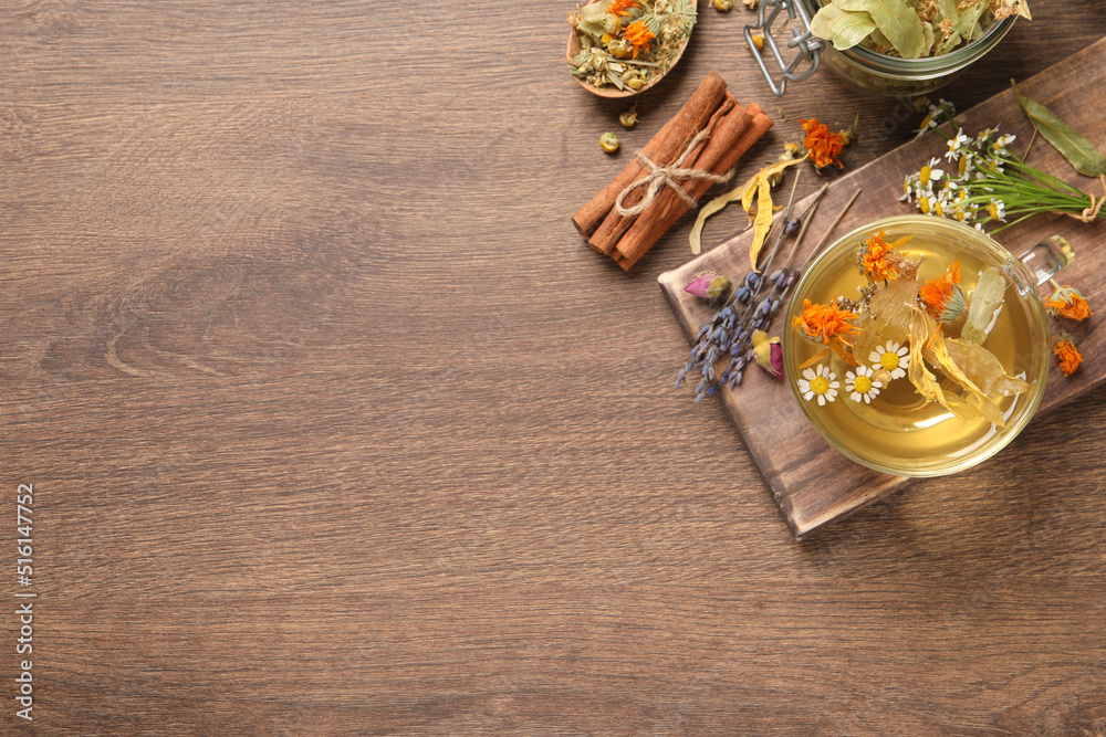 Freshly brewed tea and dried herbs on wooden table, flat lay. Space for text Freshly brewed tea and dried herbs on wooden table, flat lay. Space for text