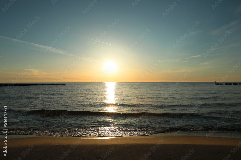 Fototapeta premium Picturesque view of sandy beach and sea at sunset