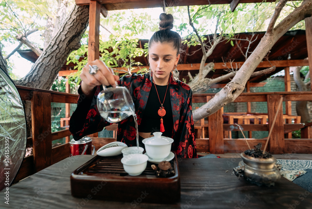 The tea ceremony. Woman pours water in a tea bowl. The tea ceremony. Woman pours water in a tea bowl.