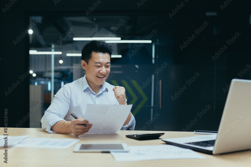 Successful and confident asian businessman reading bank letter and financial report, happy and celebrating triumph success, holding hand up Successful and confident asian businessman reading bank letter and financial report, happy and celebrating triumph success, holding hand up