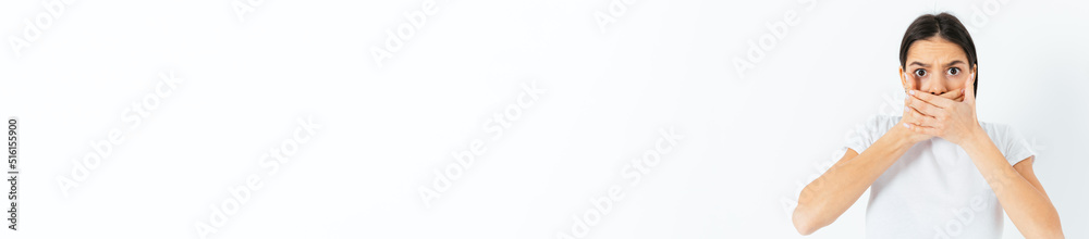 Frightened young woman covers her mouth with her hands Frightened young woman covers her mouth with her hands