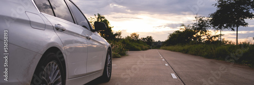 Behind a beautiful white car parked on a road with beautiful sunsets. with space for text. © PIPAT