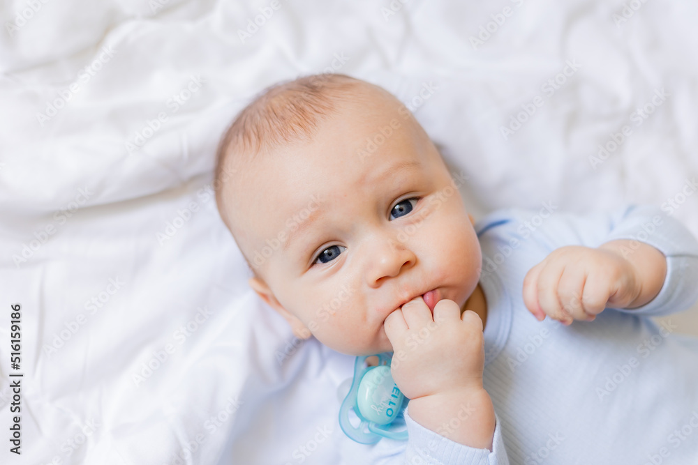 cute little boy in blue body laying on blanket, card, banner, health, space for text cute little boy in blue body laying on blanket, card, banner, health, space for text