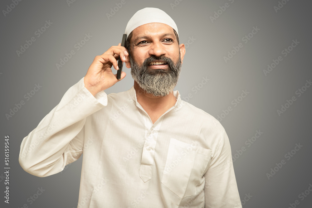 Happy asian indian muslim man talking on mobile phone, isolated. Happy asian indian muslim man talking on mobile phone, isolated.