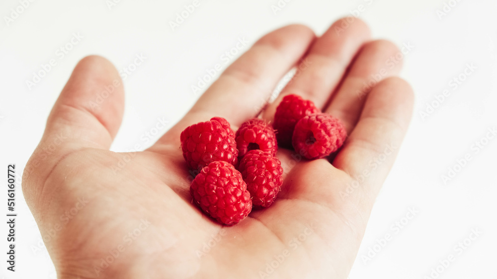 Fresh raspberry in male hand on white background Fresh raspberry in male hand on white background