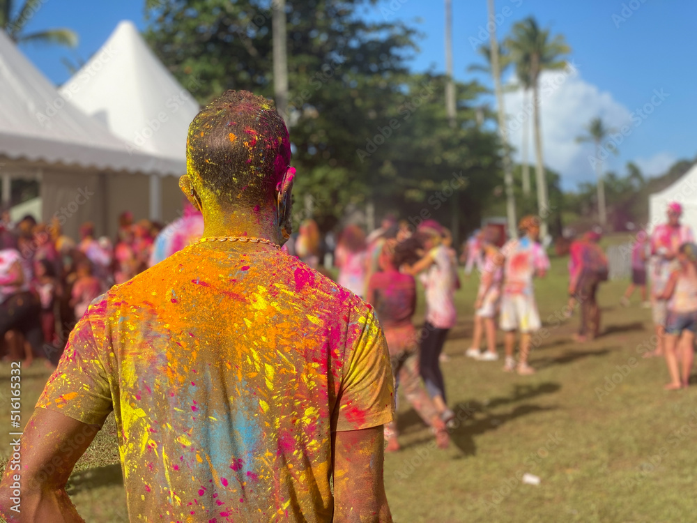 Handsome man covered with colorful powder during Holi festival in Reunion island