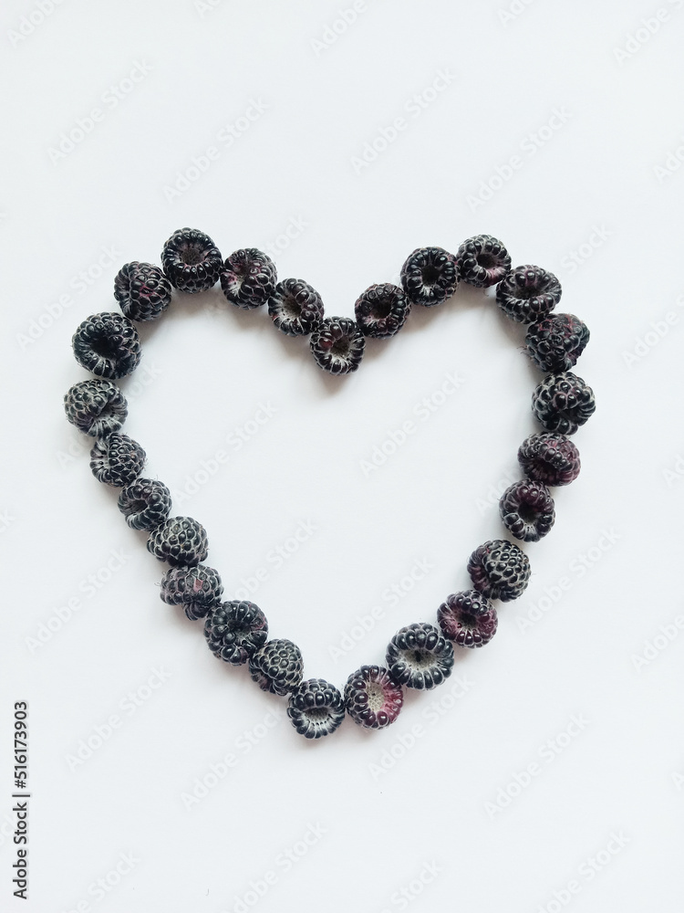 black raspberry heart. The figure of the heart is lined with ripe black raspberry berries on a white background. black raspberry heart. The figure of the heart is lined with ripe black raspberry berries on a white background.