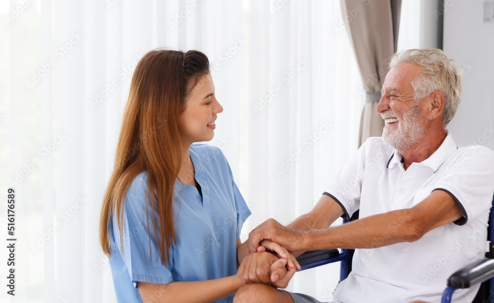 Obraz premium female doctor helping care holding hands to encourage talk Caucasian older man, older adult, patient in a wheelchair