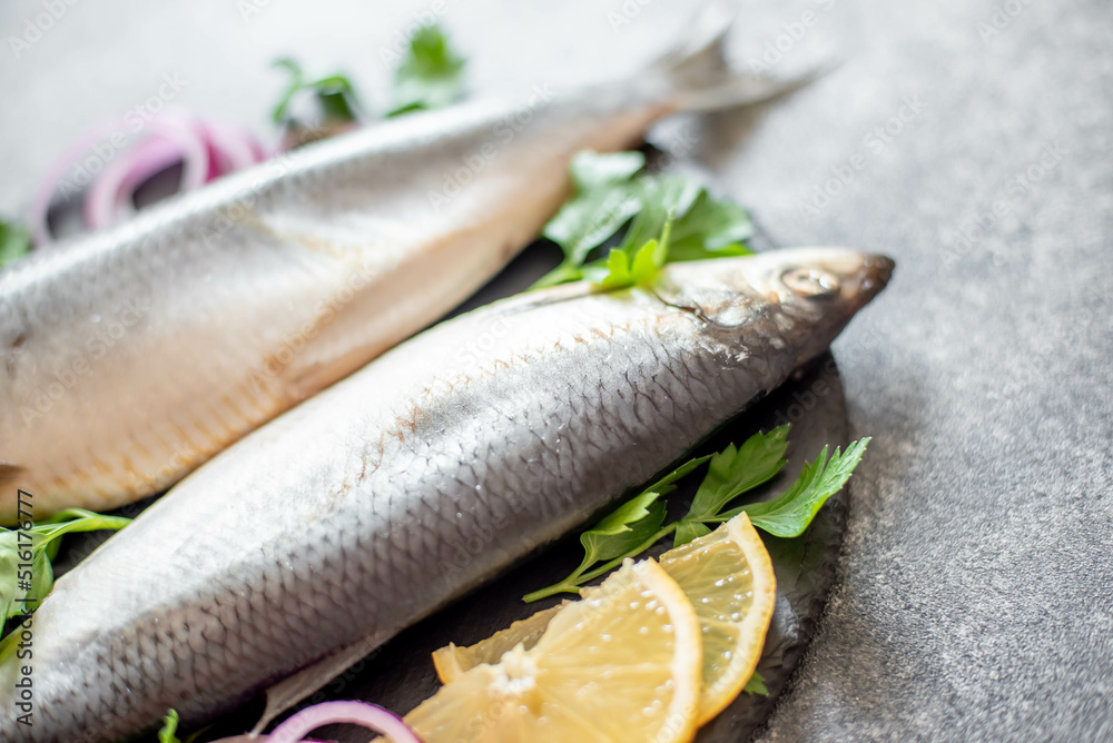 salted herring with red onion and parsley on stone background salted herring with red onion and parsley on stone background