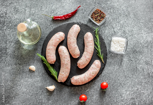 raw sausages from turkey meat with spices on a stone background