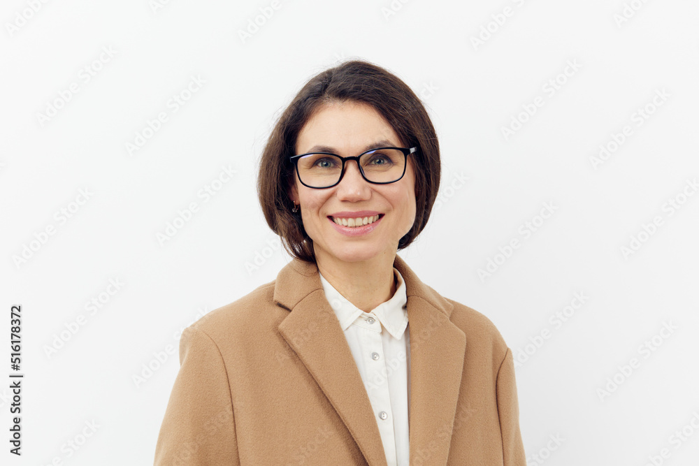 portrait of a cute, beautiful, attractive woman in glasses on a light background in a stylish brown coat. Horizontal photo on a light background with empty space portrait of a cute, beautiful, attractive woman in glasses on a light background in a stylish brown coat. Horizontal photo on a light background with empty space
