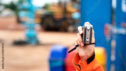 An auditor is using digital compact cemera taking photo during perform safety audit at construction site. Industrial working action scene photo, selective focus.