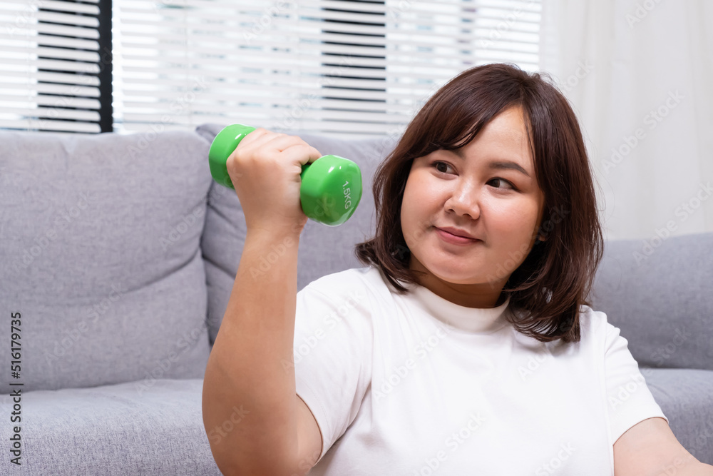 Young Asian chubby woman hold dumbbell for exercise and weight training. Fighting while diet during weight loss program with positive emotion. Portrait shot on white background. Young Asian chubby woman hold dumbbell for exercise and weight training. Fighting while diet during weight loss program with positive emotion. Portrait shot on white background.