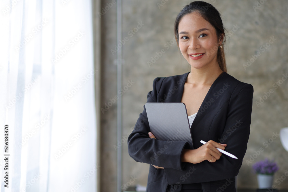 Portrait of a beautiful Asian business woman standing looking at the camera in the office. Portrait of a beautiful Asian business woman standing looking at the camera in the office.