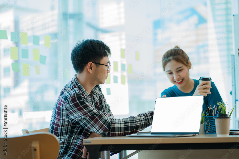 Smiling woman explains the project strategy of serious Asian colleagues. Female and male startup colleagues discuss working in a modern office using computers. Smiling woman explains the project strategy of serious Asian colleagues. Female and male startup colleagues discuss working in a modern office using computers.