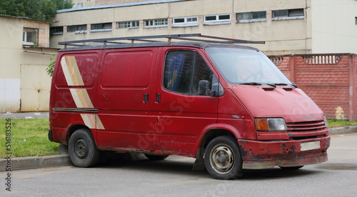 An old rusty red minibus is parked on the street, Podvoysky Street, St. Petersburg, Russia, July 2022 © Станислав Вершинин