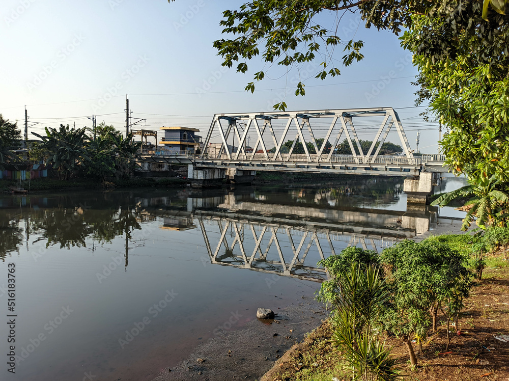 morning river view in jakarta indonesia with railway over the river