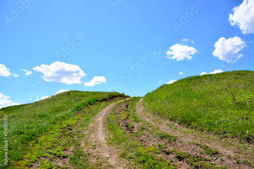Fototapeta Naklejka Na Ścianę i Meble -  country road going up to the hill to the blue sky