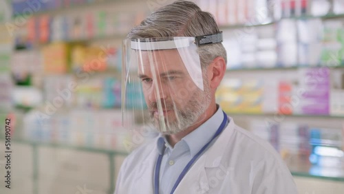 Closeup pharmacy worker caucasian mature male in face shield protective facewear against virus infections. Coronavirus. Pandemic. Pharmacy. photo