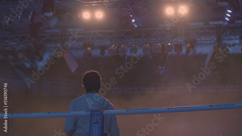 Εκτύπωση καμβά Back view of working gaffer or lighting technician and spotlights background