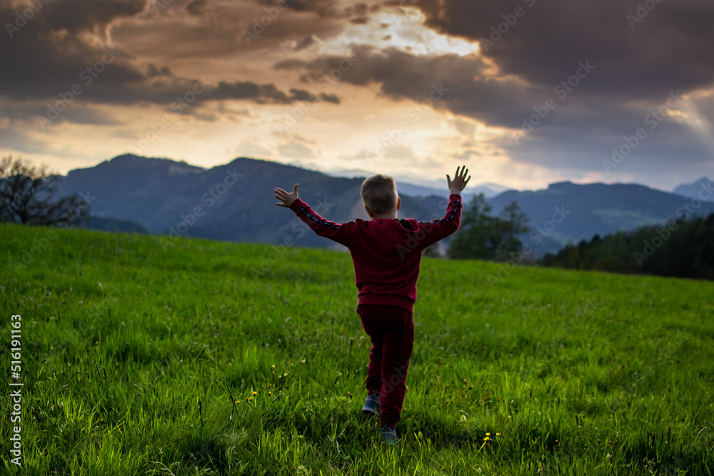 little boy runs in the rays of the sunset, hiking in the mountains little boy runs in the rays of the sunset, hiking in the mountains