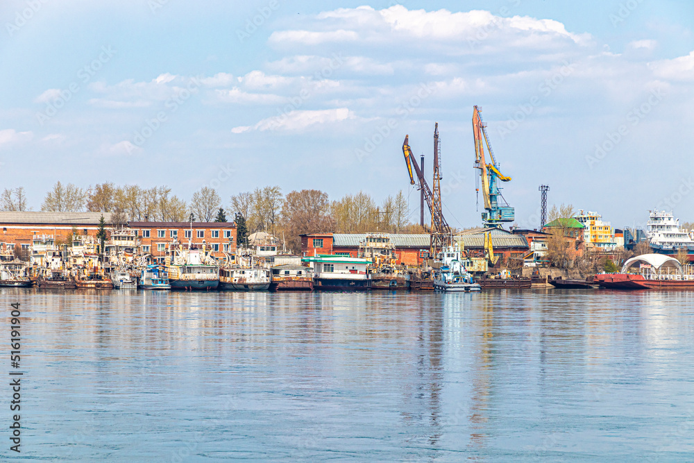 River port with moored old ships and cargo cranes