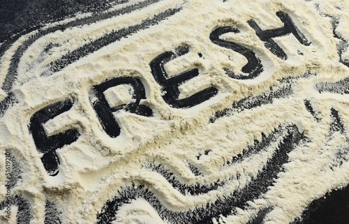 The word fresh on flour on a black background