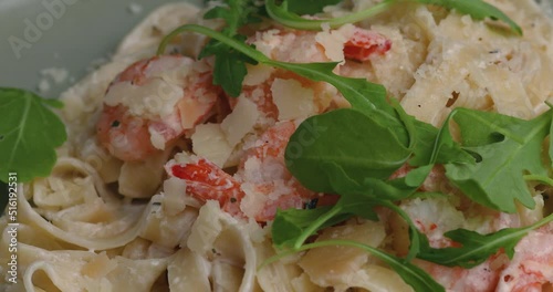 IItalian shrimp pasta with arugula. talian shrimp pasta topped with arugula. photo