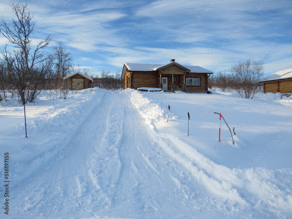 Rural houses in Snowy landscape of Lapland. Polar extreme temperatures and nature in countryside. Thick layer of snow. Snowy town of the polar circle.