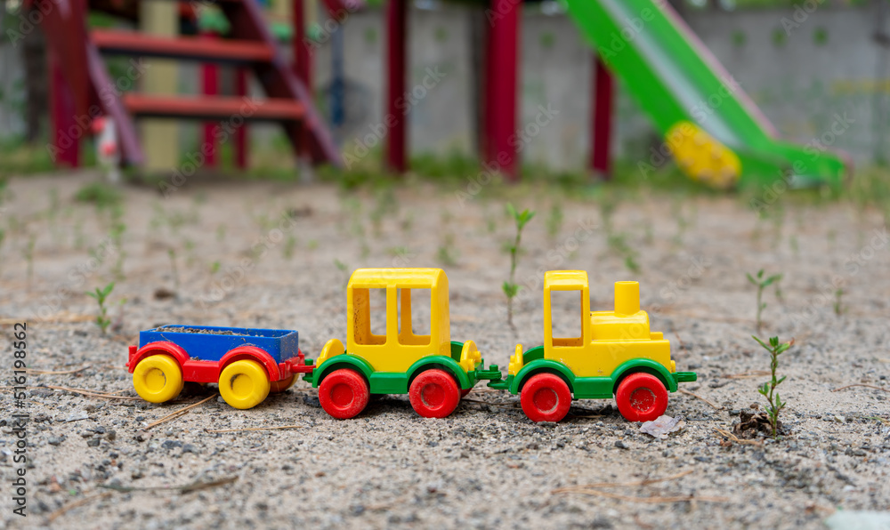 A toy plastic truck of bright colors on the playground on sunny day