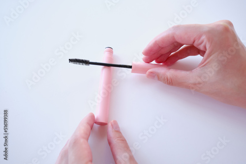 Girl hold mascara. Eyelash brush. Pink tube of mascara. Makeup cosmetics