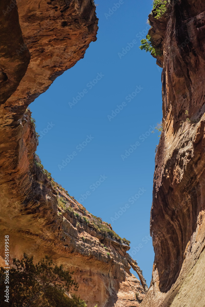 Looking up at a window of blue sky between overhanging cliff walls on the Echo Ravine Hike in Golden Gate Highlands National Park near Clarens, South Africa