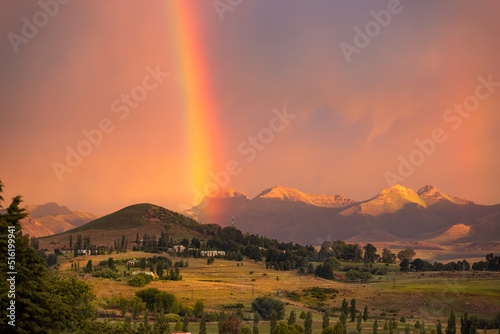 View of a rainbow at sunset against a backdrop of mountains in the town of Clarens, South Africa photo