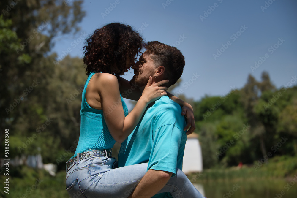 Attractive young couple in love, looking into each other's eyes, close faces about to kiss, where he is holding her piggyback. Concept love, passion, desire, lovers, Valentine's Day, kiss. Attractive young couple in love, looking into each other's eyes, close faces about to kiss, where he is holding her piggyback. Concept love, passion, desire, lovers, Valentine's Day, kiss.