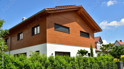 Modernes Holzhaus in Ständerbauweise mit Fassadenverkleidung aus lasiertem Nadelholz, alpine Architektur photo