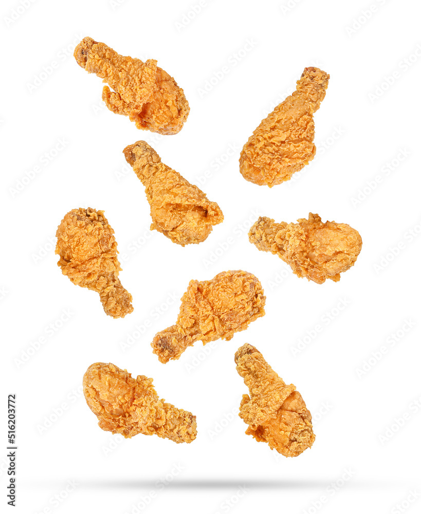 Fried chicken legs falling in the air isolated on white background. Fried chicken legs falling in the air isolated on white background.