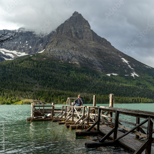 Man enjoys the warm sunlight on a dock St, Mary Lake Montana photo