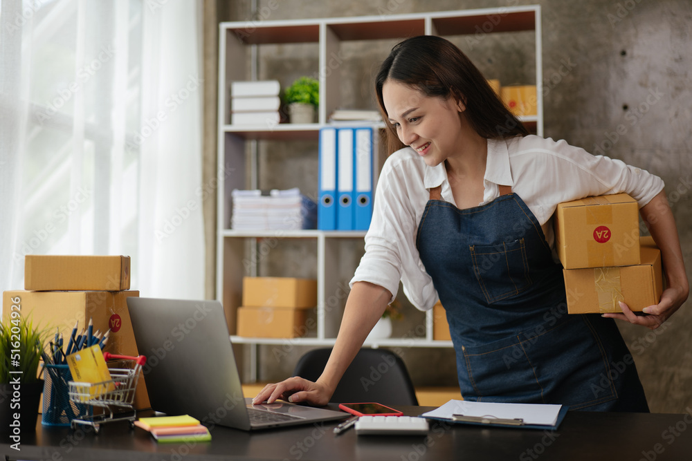 Business woman happy and cheerful for successful for receiving orders from customer via laptop with a lot of parcel boxes for shipping. Business woman happy and cheerful for successful for receiving orders from customer via laptop with a lot of parcel boxes for shipping.