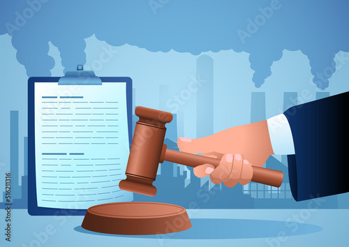 Hand holding gavel justice hammer with polluted factories on the background