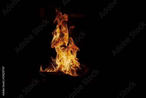 The fiery orange flame, the fire of burning in the darkness of the night. warm and dangerous abstract background